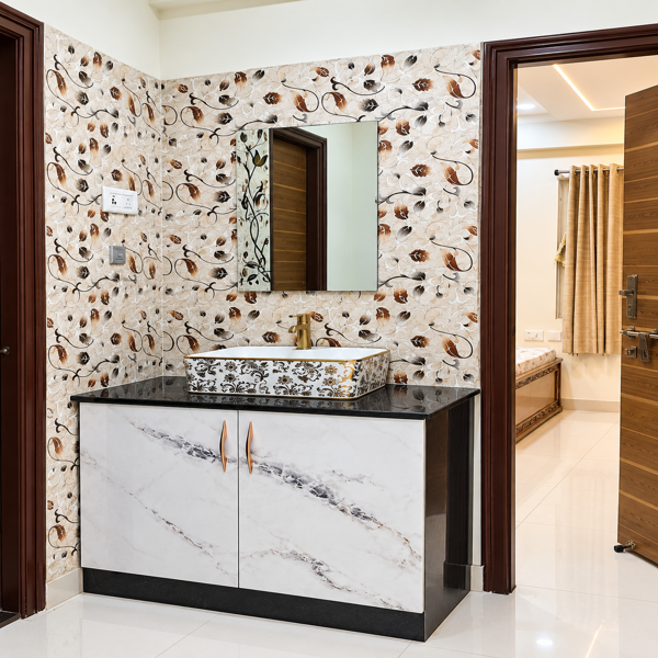    Modern wash basin, bathroom vanity, vanity cabinet, marble vanity, floral wall tiles, decorative bathroom tiles, mirror cabinet, countertop basin, vessel sink, bathroom interior, Indian bathroom design, contemporary bathroom, luxury bathroom, white marble finish, black countertop, gold faucet, bathroom faucet, vanity mirror, wall mirror, bathroom storage, under sink cabinet, floating vanity, freestanding vanity, patterned backsplash, floral tile pattern, botanical tiles, brown floral tiles, cream tiles, black marble counter, modern sanitaryware, wash basin area, powder room, guest bathroom, master bathroom vanity, residential bathroom, home interior, interior design, bathroom decor, elegant bathroom, premium bathroom, contemporary home, modern Indian home, custom vanity, modular bathroom cabinet, storage drawers, cabinet handles, wall mounted mirror, mirror design, decorative backsplash, tile design, marble laminate, stone texture, polished surface, gold hardware, wooden door, dark wood trim, doorway interior, bedroom doorway, neutral color palette, warm tones, sophisticated decor, functional vanity, bathroom renovation, home renovation, bathroom makeover, modern washroom, wash basin design, sink cabinet, countertop vanity, designer bathroom, interior styling, clean lines, luxury interiors, residential interiors, apartment bathroom, Indian home interiors, contemporary styling, decorative wall, accent wall, floral decor, elegant tiles, patterned wall, compact vanity, spacious vanity, practical storage, bathroom organization, modern fixtures, premium fittings, faucet design, mirror installation, interior inspiration, home decor ideas, bathroom design ideas, modern vanity unit, custom cabinetry, polished bathroom, sophisticated bathroom, functional bathroom, beautiful bathroom, bathroom photography.